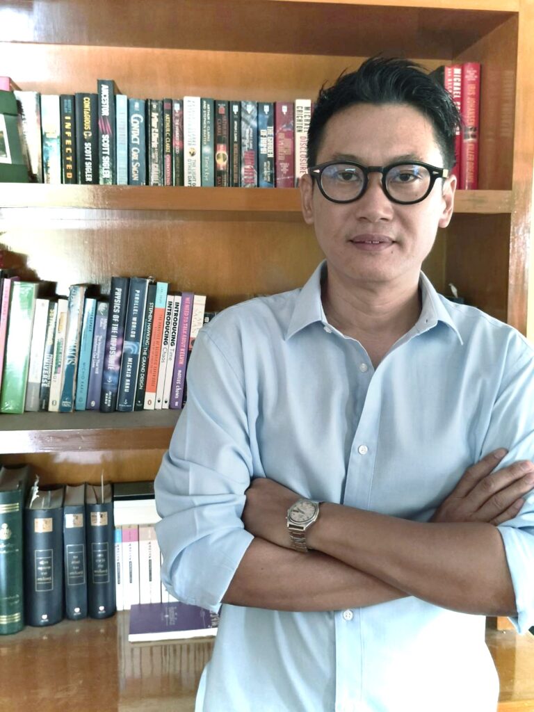 Meditate coach standing in front of the bookshelf